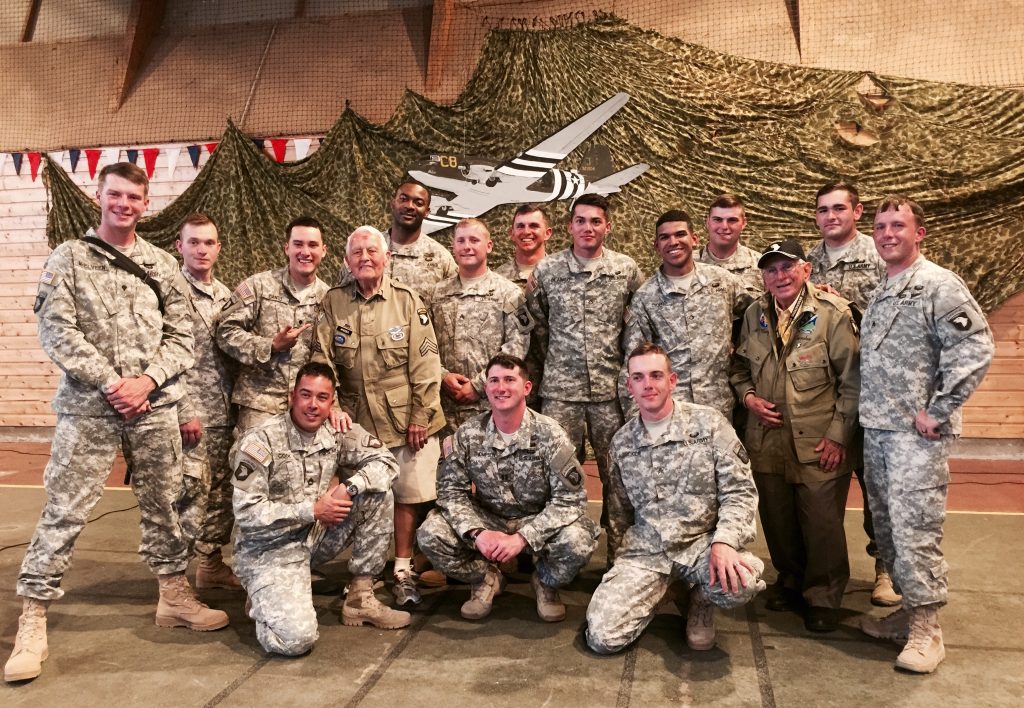 Soldiers posting for a photo with veterans